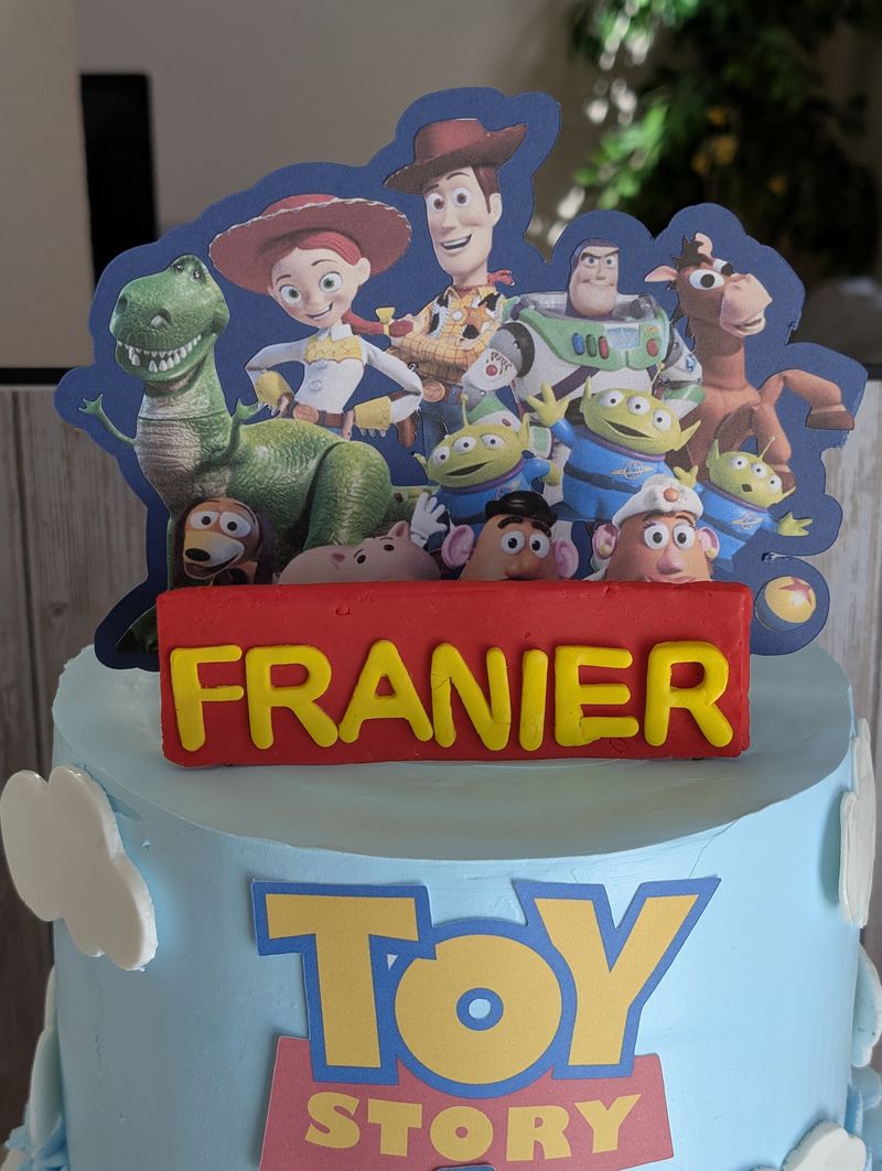 Toy Story themed birthday cake topper on a blue cake