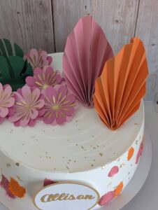 Topper floral personalizado sobre un pastel de buttercream